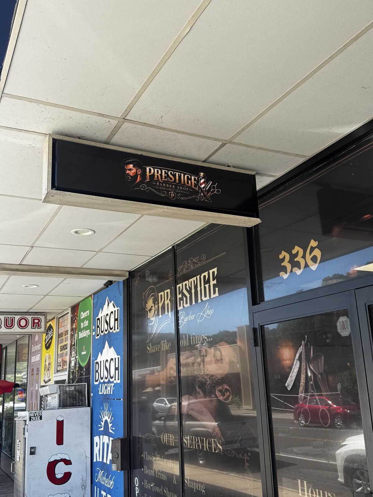 Prestige Barbershop storefront signage above the new window graphics